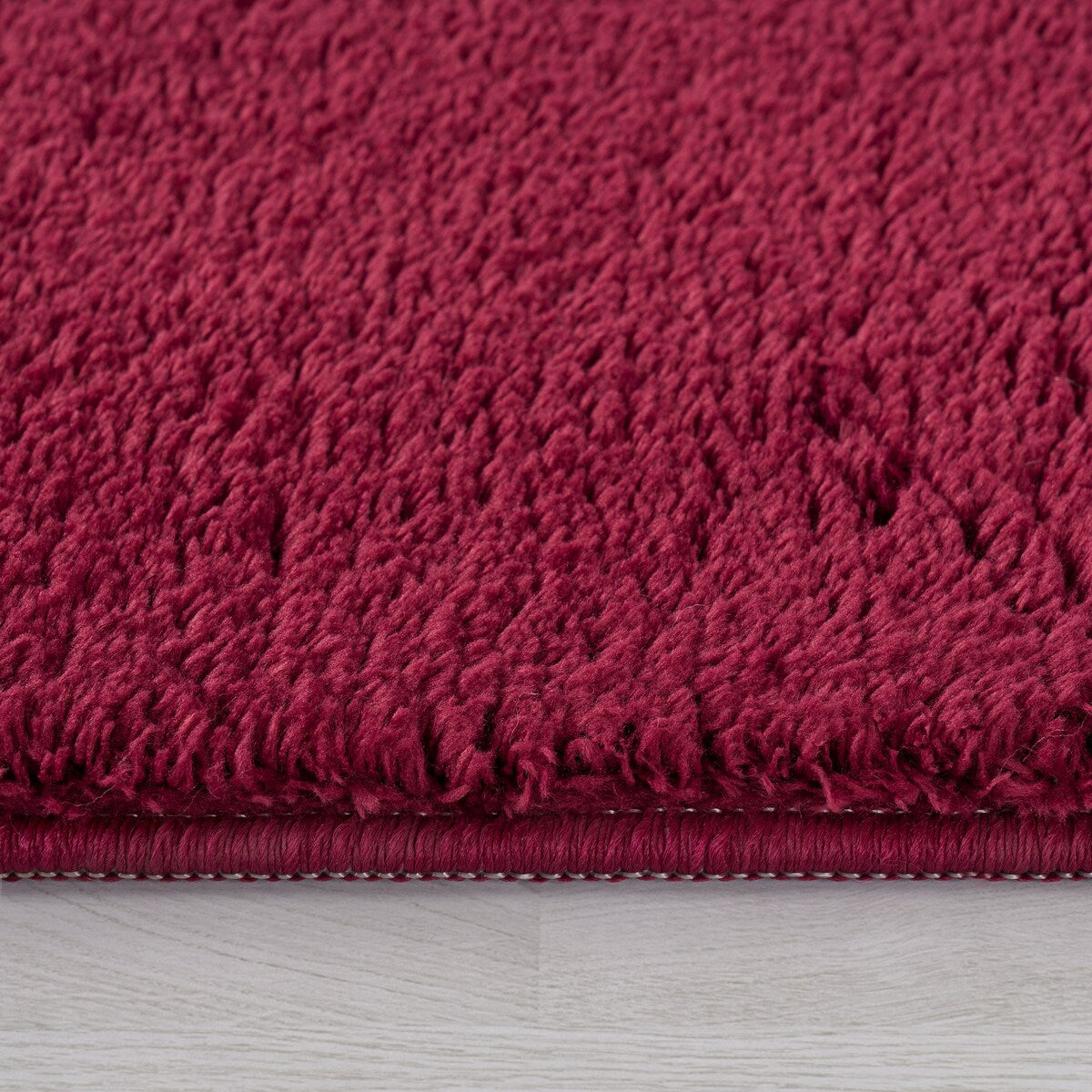 Tapis doux et lavable avec envers antidérapant, disponible en couleurs unies.